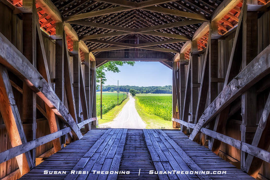 Standing inside the McAllister Covered Bridge in Parke County, Indiana, looking out at the country lane and cornfields is a cool escape from the midday summer heat. Parke County, with 31 covered bridges, is known as the “Covered Bridge Capitol of the World.”