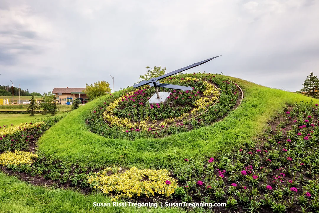   
The International Peace Garden’s Floral Clock, an 18‑foot living timepiece gifted by the Bulova Watch Company in 1966, sits in full bloom near the United States border crossing. Its face is planted with thousands of yellow and magenta flowers arranged by hand in a seasonal design that reflects regional culture. The clock’s raised hands rest on a grassy mound, representing a blend of artistry, horticulture, and engineering. Originally planted with 3,500 blooms and powered by a mechanism that kept time from 1967 until its replacement in 2005, the landmark remains a symbol of international goodwill and a popular photo stop.